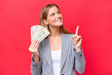 Kafkasyalı genç bir kadının elinde kırmızı arka planda izole edilmiş para olması harika bir fikre işaret ediyor.