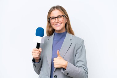 Genç TV sunucusu beyaz arka planda izole edilmiş beyaz bir kadın. Başparmakları havada çünkü iyi bir şey oldu.