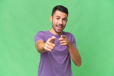 Soyutlanmış geçmişi olan yakışıklı beyaz bir adam şaşırmış ve ön tarafı işaret ediyor.