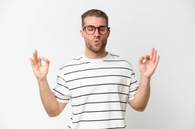 Zen pozisyonunda beyaz arka planda izole edilmiş yakışıklı beyaz bir adam.