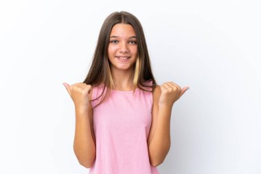 Beyaz arka planda izole edilmiş beyaz bir kız. Baş parmakları havada ve gülümsüyor.