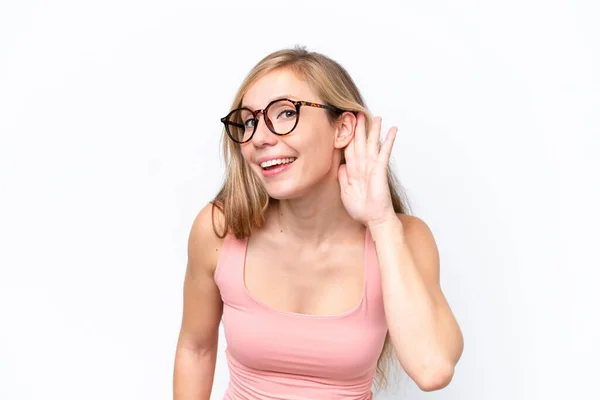 stock image Young caucasian woman isolated on white background listening to something by putting hand on the ear