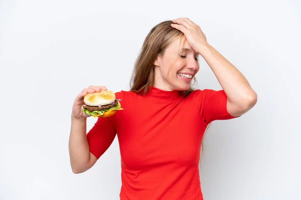 Młoda Blondynka Trzymająca Hamburgera Białym Tle Zdała Sobie Czegoś Sprawę — Zdjęcie stockowe