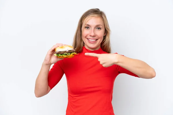 Young Blonde Woman Holding Burger Isolated White Background Pointing — Stock Photo, Image