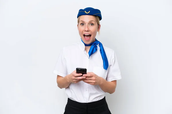 飛行機ブロンドスチュワーデス女性は驚いて白い背景に隔離され メッセージを送信 — ストック写真