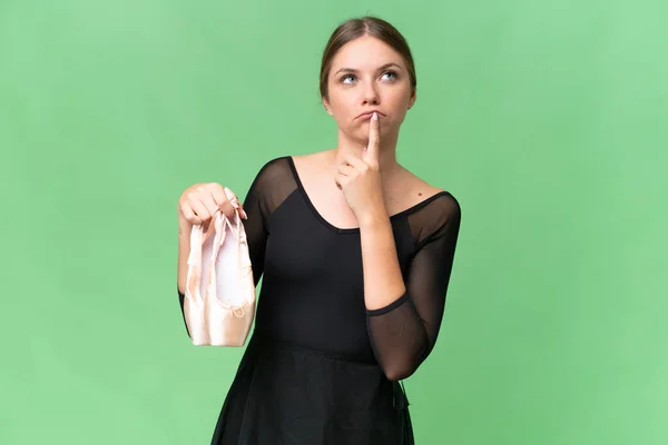 stock image Young beautiful blonde woman practicing ballet over isolated background having doubts while looking up