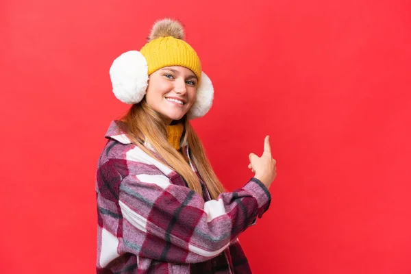 Junge Schöne Frau Trägt Wintermuffs Isoliert Auf Rotem Hintergrund Der — Stockfoto
