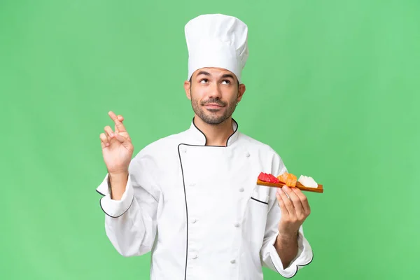 Joven Chef Caucásico Sosteniendo Sushi Sobre Fondo Aislado Con Los — Foto de Stock
