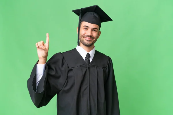 Mladá Univerzita Absolvent Muž Přes Izolované Pozadí Ukazující Zvednout Prst — Stock fotografie