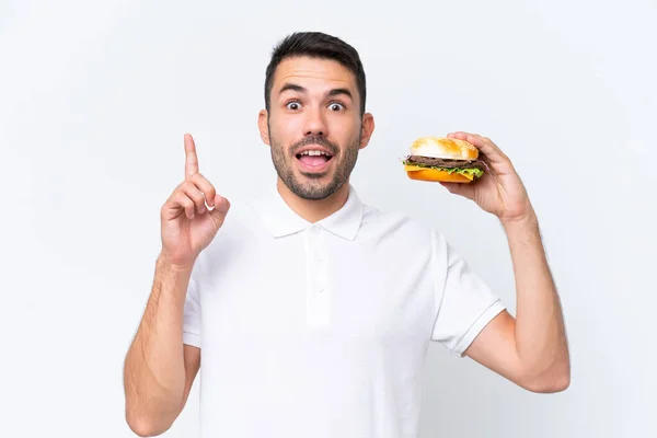 Młody Przystojny Biały Mężczyzna Trzymając Hamburgera Odosobnione Tło Wskazując Górę — Zdjęcie stockowe