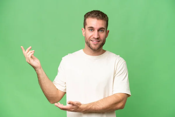 Νεαρός Όμορφος Καυκάσιος Άνδρας Απομονωμένος Πράσινο Χρωματικό Υπόβαθρο Απλώνει Χέρια — Φωτογραφία Αρχείου