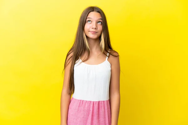 Pequena Menina Caucasiana Isolado Fundo Amarelo Olhando Para Cima — Fotografia de Stock