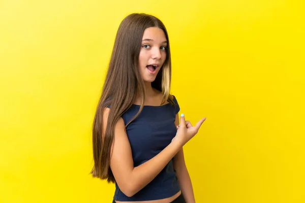 Little Caucasian Girl Isolated Yellow Background Surprised Pointing Side — Stock Photo, Image