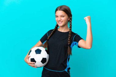 Mavi arka planda izole edilmiş beyaz bir kız futbol topuyla zaferi kutluyor.