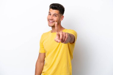 Beyaz arka planda izole edilmiş genç beyaz adam parmağını kaldırıyor ve gösteriyor.