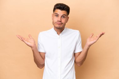 Beyazların arka planında izole edilmiş genç beyaz adam şüpheli hareketler yapıyor.