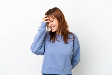 Kızıl saçlı kız beyaz arka planda yalnız gülüyor.