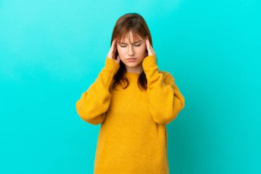Kızıl saçlı kız mavi arka planda baş ağrısı ile izole edilmiş.