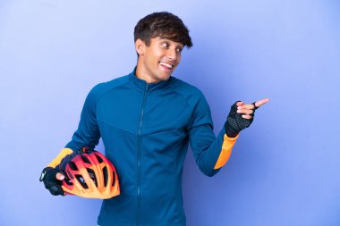 Mor arka planda izole edilmiş genç beyaz adam çözümü bulmak için parmağını kaldırıyor.