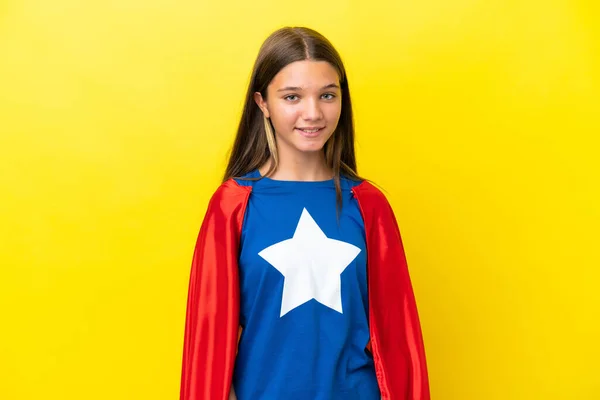 stock image Little caucasian superhero girl isolated on yellow background laughing
