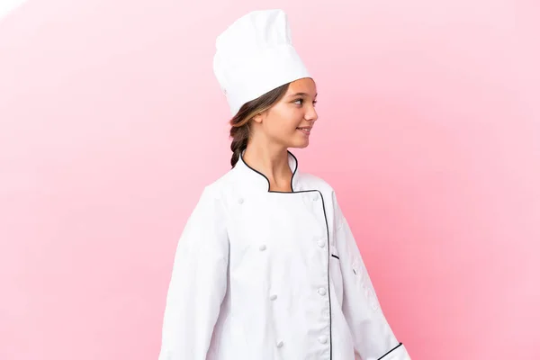 Piccola Ragazza Chef Caucasico Isolato Sfondo Rosa Cercando Lato — Foto Stock