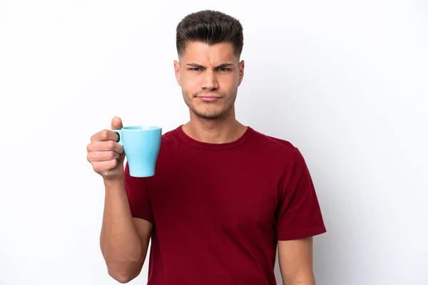 Młody Biały Mężczyzna Trzyma Filiżankę Kawy Białym Tle Smutnym Wyrazem — Zdjęcie stockowe