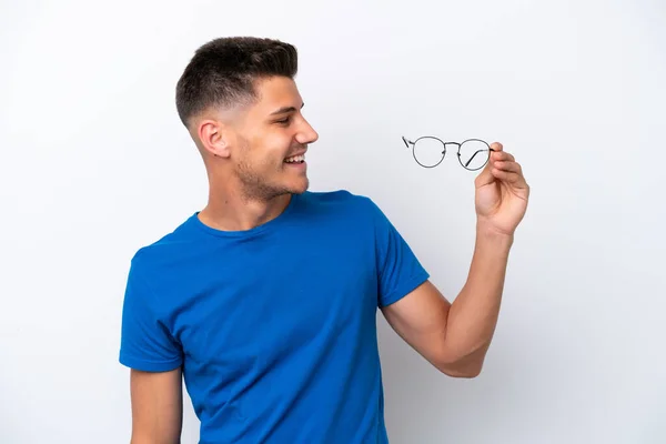 Ung Kaukasisk Man Hålla Glasögon Isolerade Vit Bakgrund Med Glada — Stockfoto
