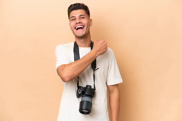 Νεαρός Φωτογράφος Καυκάσιος Άνδρας Απομονωμένος Μπεζ Φόντο Γιορτάζει Μια Νίκη — Φωτογραφία Αρχείου