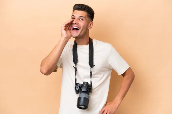年轻的摄影师高加索人男子孤立在米黄色的背景下大喊着 张大了嘴 — 图库照片
