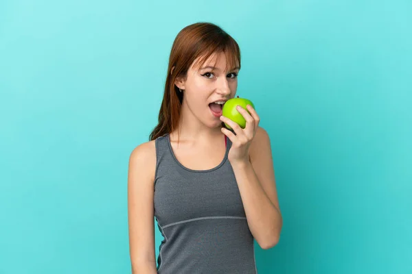 Vörös Lány Elszigetelt Kék Háttér Eszik Egy Almát — Stock Fotó