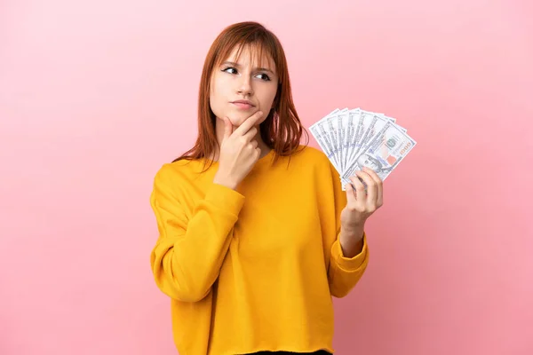Redhead Girl Taking Lot Money Isolated Pink Background Having Doubts — Foto de Stock