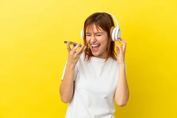 Pelirroja Aislada Sobre Fondo Amarillo Escuchando Música Con Móvil Cantando —  Fotos de Stock