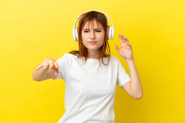 赤毛女の子絶縁上の黄色の背景リスニング音楽とダンス — ストック写真