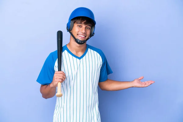 野球の白人男性選手とヘルメットとバットが青い背景に隔離され 招待状が来るために側に手を伸ばし — ストック写真