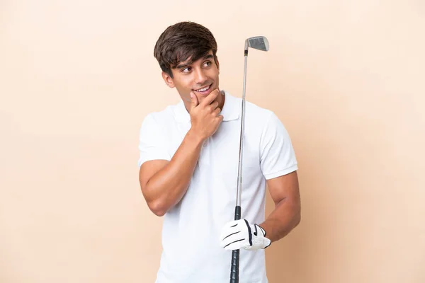 Joven Jugador Golf Hombre Aislado Sobre Fondo Ocre Mirando Lado —  Fotos de Stock