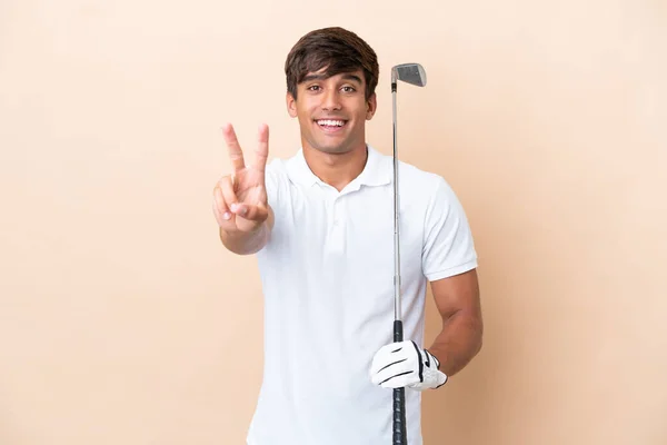 Joven Jugador Golf Hombre Aislado Sobre Fondo Ocre Sonriendo Mostrando —  Fotos de Stock