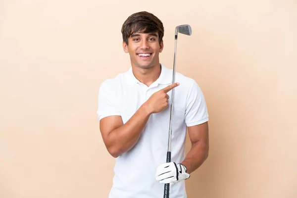 年轻的高尔夫球手男子孤立在弓箭手的背景下指向一边介绍一种产品 — 图库照片