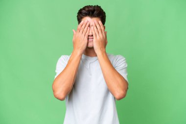 Young caucasian handsome man over isolated background covering eyes by hands