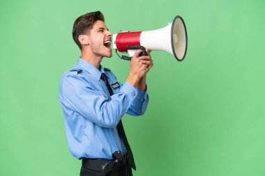 Genç bir polis memuru arka planda megafonla bağırıyor.