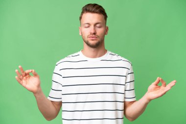 Zen pozisyonunda, izole edilmiş bir geçmişi olan genç sarışın, beyaz bir adam.