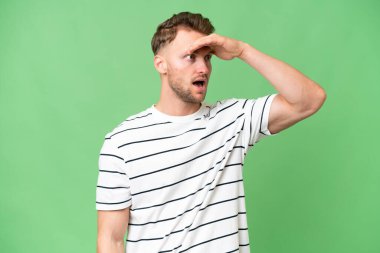 Sarışın, beyaz, soyutlanmış bir adam. Yan tarafa bakarken sürpriz jest yapıyor.