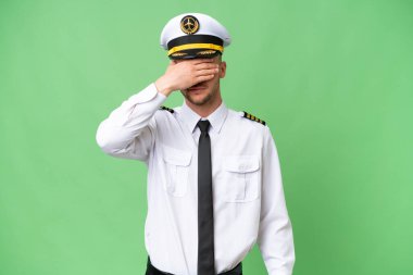 Uçak pilotu, izole edilmiş arka planda, gözleri elleriyle kapatıyor. Bir şey görmek istemiyorum.