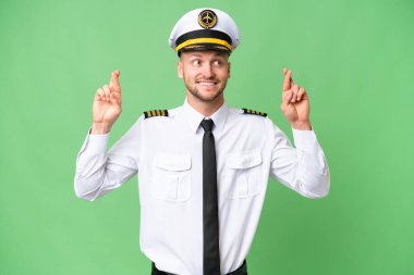 Uçak pilotu arka planda izole edilmiş ve parmakları çapraz