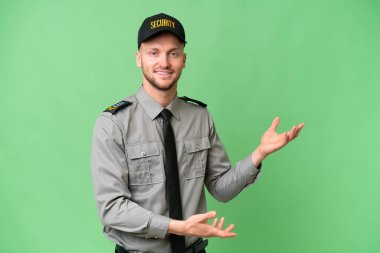 İzole edilmiş arka planda genç bir beyaz adam. Davet edilmek için ellerini yana uzatıyor.