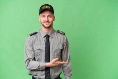 İzole edilmiş arka planda genç bir beyaz adam gülümserken bir fikir sunuyor.