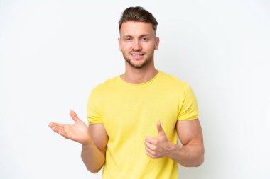 Beyaz arka planda izole edilmiş genç, sarışın beyaz bir adam. Elinde bir reklam vermek ve onaylamak için bir fotokopi odası hayali tutuyor.