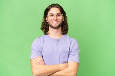 Tecrit edilmiş genç ve yakışıklı bir adam kollarını ön cephede kavuşturuyor.