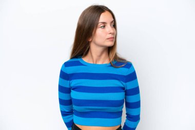 Beyaz arka planda izole edilmiş genç beyaz kadın yan tarafa bakıyor.