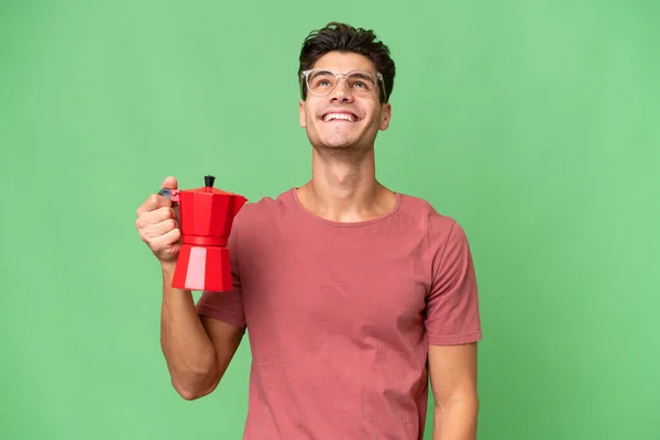 Jonge Kaukasische Man Houden Koffie Pot Geïsoleerde Achtergrond Zoek Naar — Stockfoto