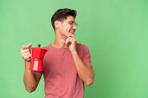 Jonge Kaukasische Man Houdt Koffie Pot Geïsoleerde Achtergrond Denken Een — Stockfoto